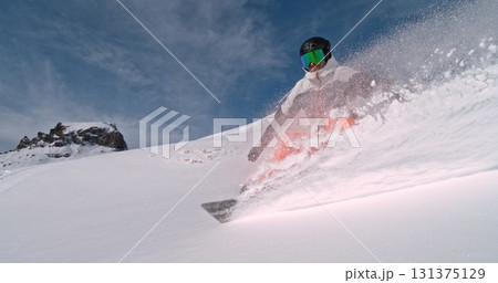 Real professional snowboarder rides at off-piste ski slope. Winter sports concept Real professional snowboarder rides at off-piste ski slope. Winter sports concept 131375129