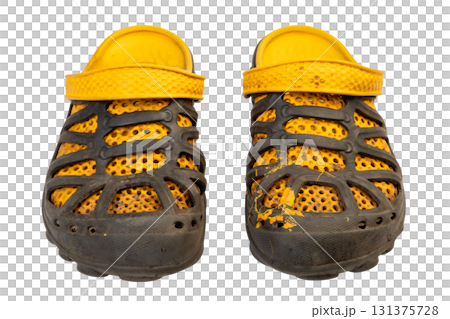 dirty worn yellow and black garden rubber sandals or shoes with perforated design isolated on white background. Front view 131375728