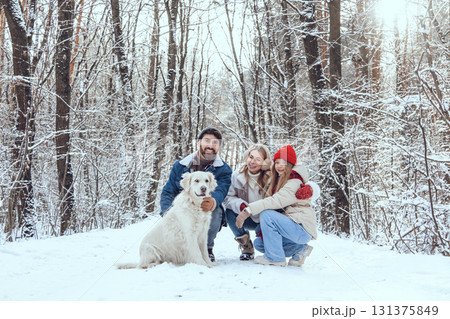 Cute young family and their dog spending day in winter forest 131375849