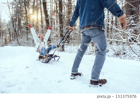 Man pulling sled with his wife and both feeling excited 131375876