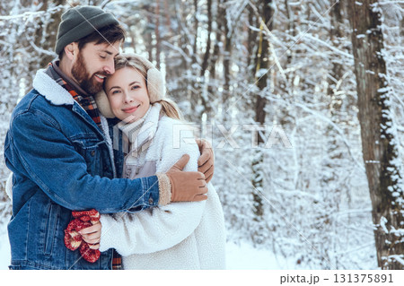 Young man and woman walking in a winter forest and feeling happy and romantic 131375891