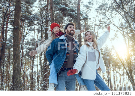 Young cute family enjoying a sunny winter day in a forest 131375923