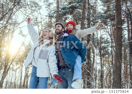 Young cute family enjoying a sunny winter day in a forest 131375924