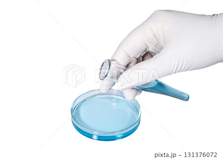Hand in medical latex glove with a test tube filled with blue liquid Hand in medical latex glove with a test tube filled with blue liquid 131376072