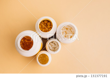 Mixed supplement containers top view on warm neutral background with copy space 131377191