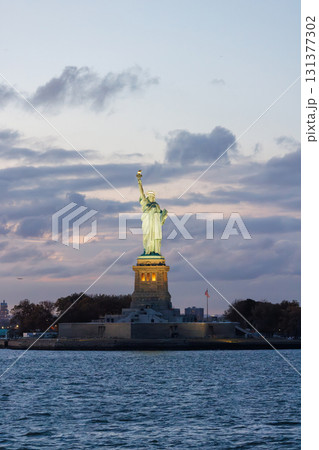 Statue of Liberty at sunset with dramatic sky and warm golden light 131377302