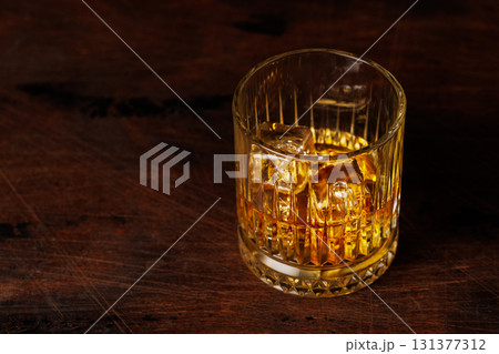 A classic whiskey glass filled with golden amber whiskey 131377312