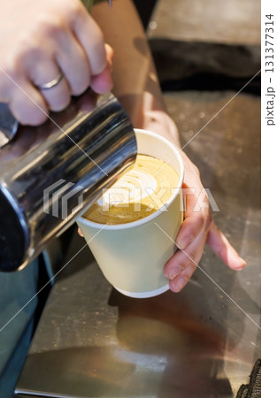 Barista crafting cappuccino with latte art 131377314