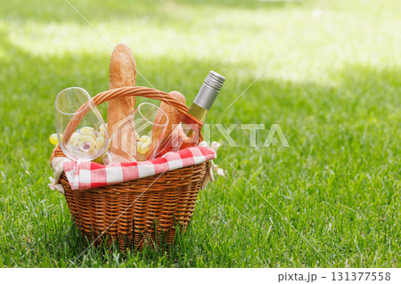 Picnic basket with wine, grapes, and baguette 131377558