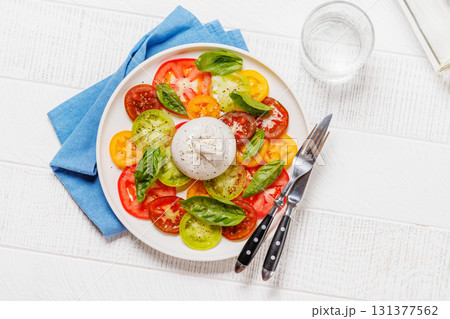 Fresh burrata served on slices of colorful tomatoes 131377562