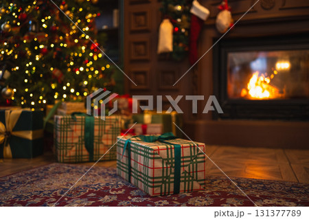 Green gift box in classical Christmas decorated interior living room library with fireplace. Christmas gift near fir tree on Christmas eve. Modern classic style interior design apartment. Christmas 131377789