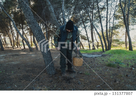 Man Using A Stick To Detect The Porcini Mushrooms On The Ground  131377807