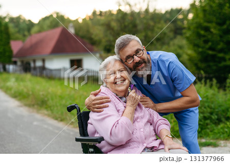 Male home nurse taking care of elderly woman in wheelchair. Male home nurse taking care of elderly woman in wheelchair. 131377966