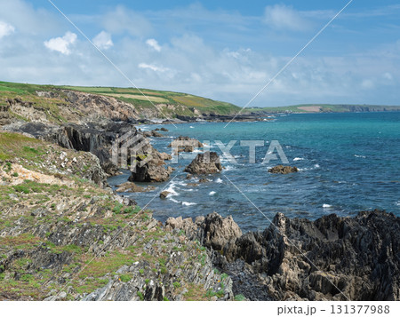 Rocky coastline against a bright blue sea. Rocky coastline against a bright blue sea. 131377988