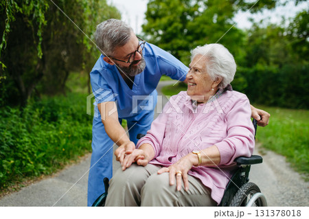 Male home nurse taking care of elderly woman in wheelchair. Male home nurse taking care of elderly woman in wheelchair. 131378018