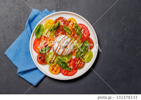 Fresh burrata served on slices of colorful tomatoes Fresh burrata served on slices of colorful tomatoes 131378133