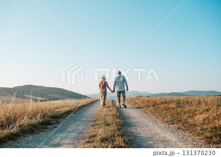 Senior couple on walk during sunset. 131378230