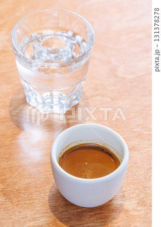Freshly brewed espresso served in a small cup on a table 131378278