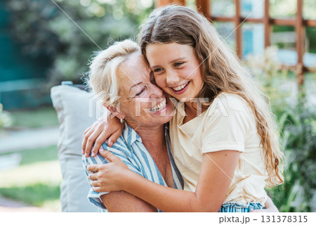 Grandmother and granddaughter hugging in the garden. Grandmother and granddaughter hugging in the garden. 131378315