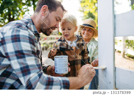 Little boy helping on farm, painting fence. Little boy helping on farm, painting fence. 131378399