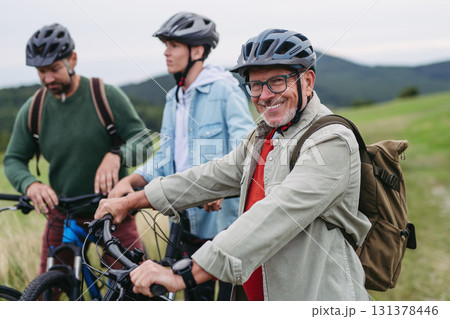 Grandfather, father and teen boy on cycling trip taking selfie. 131378446
