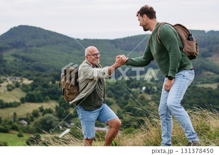 Adult son and older father hiking togeter in nature. Adult son and older father hiking togeter in nature. 131378450