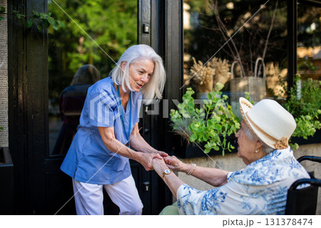 Tender moment between older caregiver and senior female patient in wheelchair. Tender moment between older caregiver and senior female patient in wheelchair. 131378474