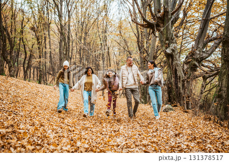 Multigenerational family portrait. Parents, grandma and daughters on walk in forest. Multigenerational family portrait. Parents, grandma and daughters on walk in forest. 131378517