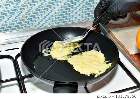 Pancakes are being fried in a frying pan 131378550