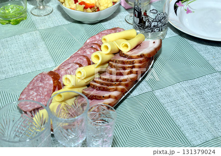 There is a plate with sliced sausage on the table. There is a plate with sliced sausage on the table. 131379024