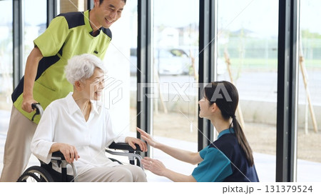 介護施設で挨拶をする高齢者と介護士 131379524