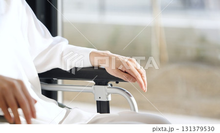 車椅子の高齢者に手を重ねる介護士 131379530