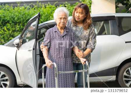 Caregiver help Asian elderly woman disability patient get in her car. Caregiver help Asian elderly woman disability patient get in her car. 131379652