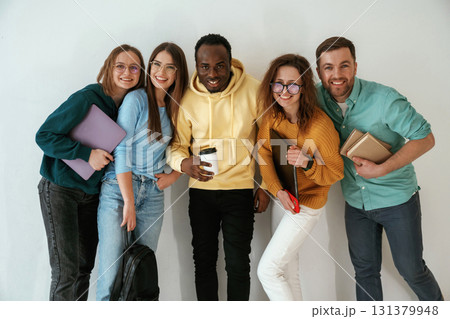 Positive friends. Group of young people are standing against white background 131379948