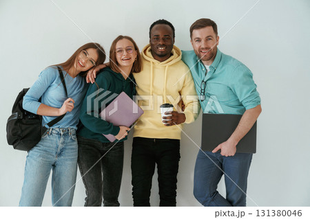 Smiling, looking forward. Group of young people are standing against white background 131380046