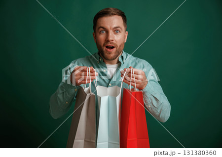 Shocked facial expression. Man is standing against background in the studio Shocked facial expression. Man is standing against background in the studio 131380360