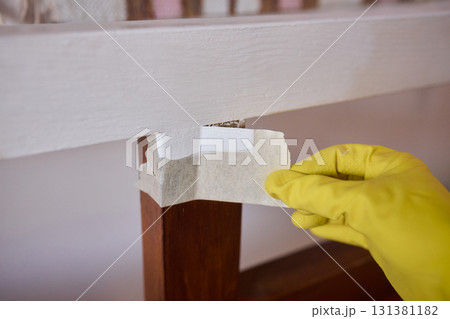 Engage in DIY chair restoration using a paint brush and protective gloves for the process 131381182