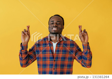 Cafe worker. Black man is in the studio against yellow background Cafe worker. Black man is in the studio against yellow background 131381264