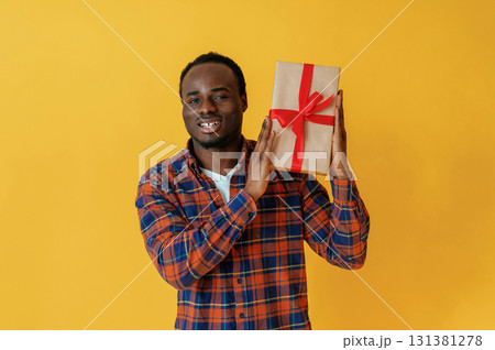 Cafe worker. Black man is in the studio against yellow background 131381278