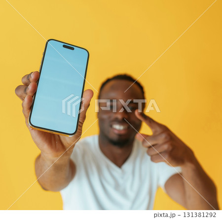 Cafe worker. Black man is in the studio against yellow background Cafe worker. Black man is in the studio against yellow background 131381292