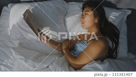 Beautiful Young Woman Reading Book in Bed in Bedroom Beautiful Young Woman Reading Book in Bed in Bedroom 131381407