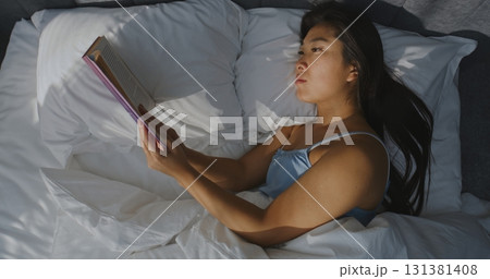 Beautiful Young Woman Reading Book in Bed in Bedroom Beautiful Young Woman Reading Book in Bed in Bedroom 131381408