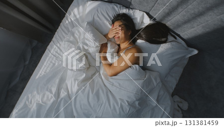 Beautiful Young Woman Wakes Up in Bedroom, Squinting From Bright Sunlight 131381459