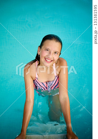 Teen girl enjoys summer in the pool, showcasing joy while relaxing in the water with a big smile Teen girl enjoys summer in the pool, showcasing joy while relaxing in the water with a big smile 131381595
