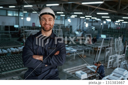 Handsome friendly guy. Factory worker is indoors with hard hat 131381667