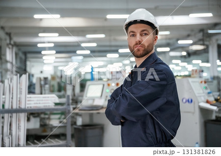 Smart employee. Factory worker is indoors with hard hat 131381826