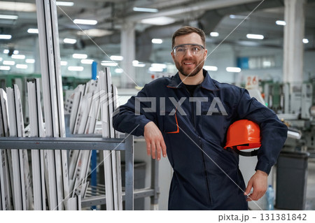 Break time, standing. Factory worker is indoors with hard hat Break time, standing. Factory worker is indoors with hard hat 131381842
