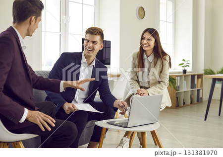 Three young business people at work in office talking and having discussion. 131381970