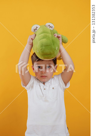 Front view. Little boy is in the studio against yellow background 131382353