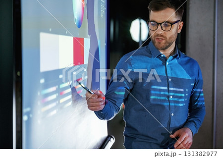 Business coach against projector with data Business coach against projector with data 131382977